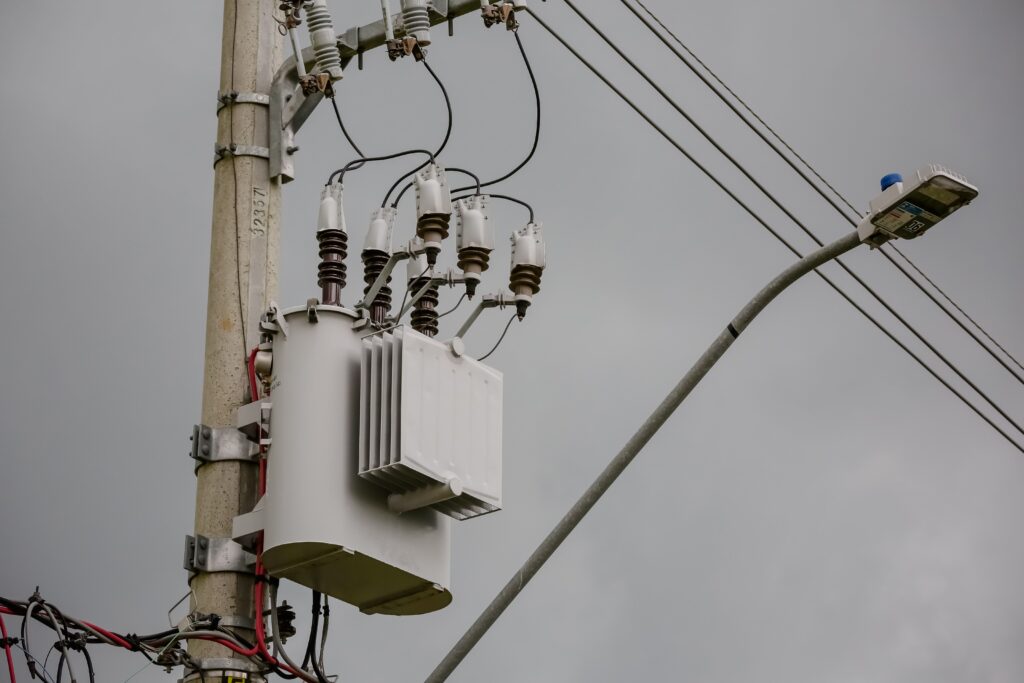Transformador a óleo instalado em poste de rede elétrica urbana
